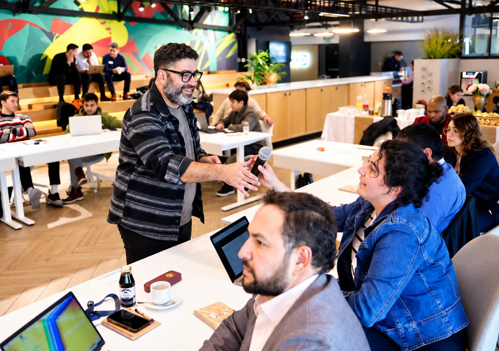 Taller de IA de NLACE con el equipo de NESsT: el relator pasa el micrófono a una participante mientras el resto trabaja en sus computadores.